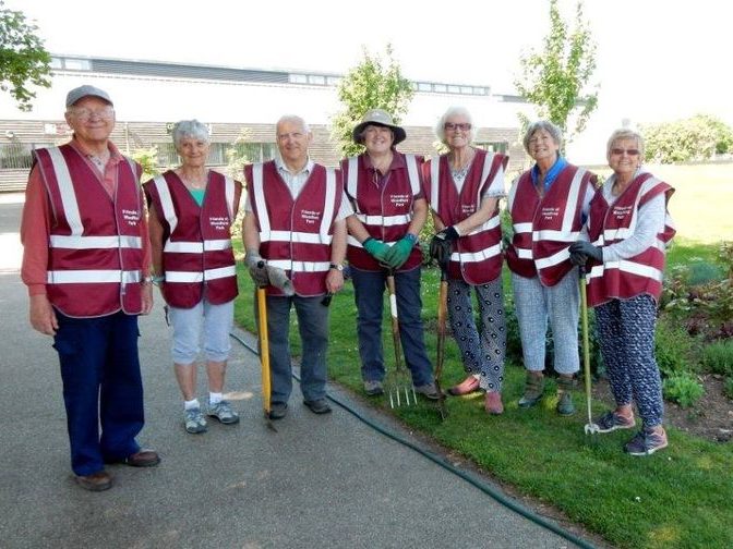 Members of the Friends of Woodford Park posing by their flower beds