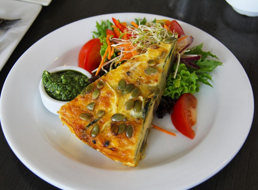 Spring quiche and salad on a white plate